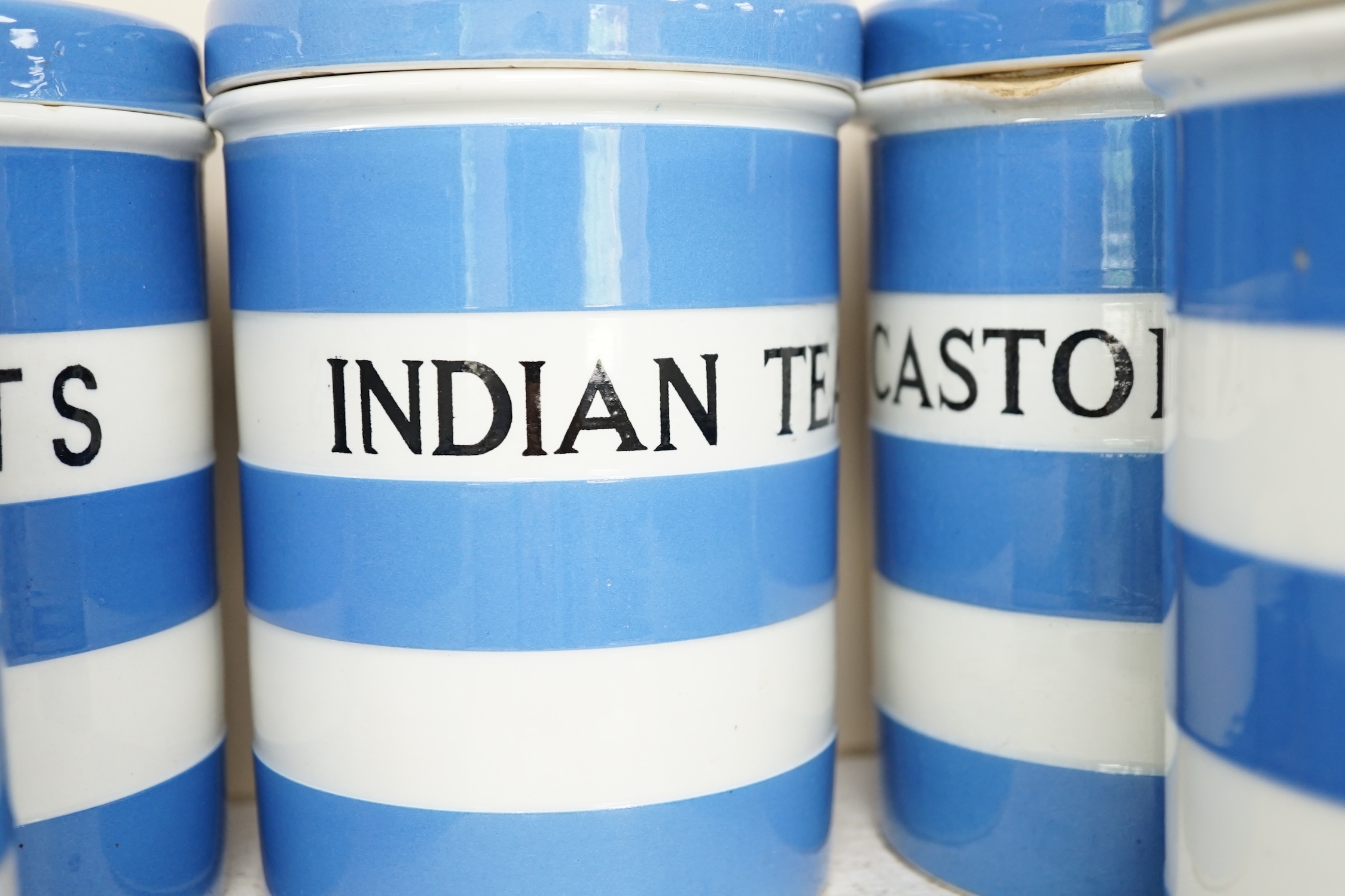 T.G.Green Cornish Kitchenware, eight 17cm lidded storage jars, comprising Currants, Caster Sugar, Granulated Sugar, Indian Tea, Macaroni, Biscuits, Pearl Barley and Quaker, Oats, Black Shield marks. Condition - fair to g